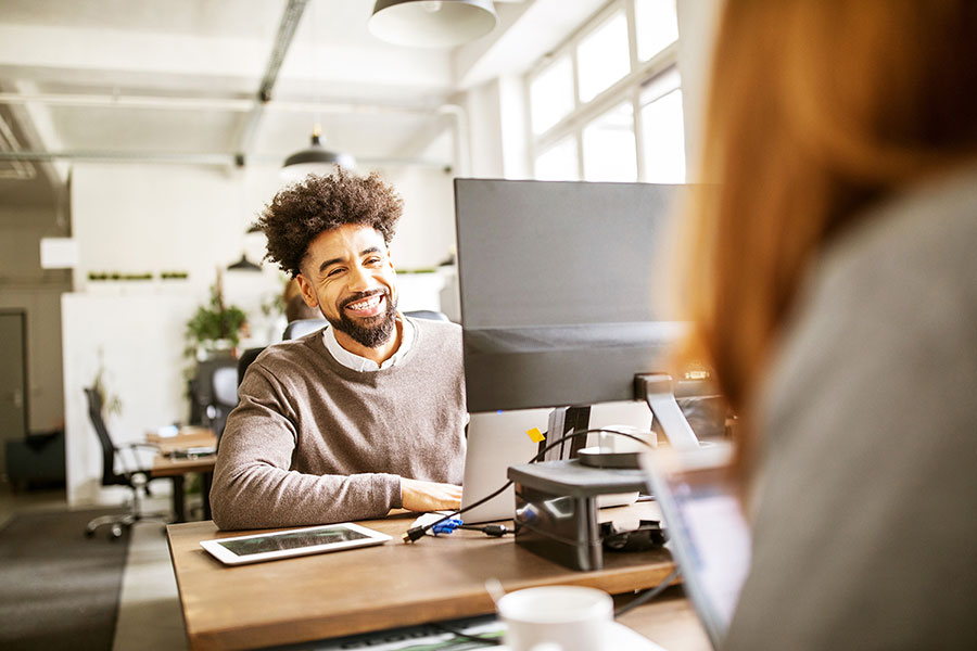 Co-workers at desk, computers