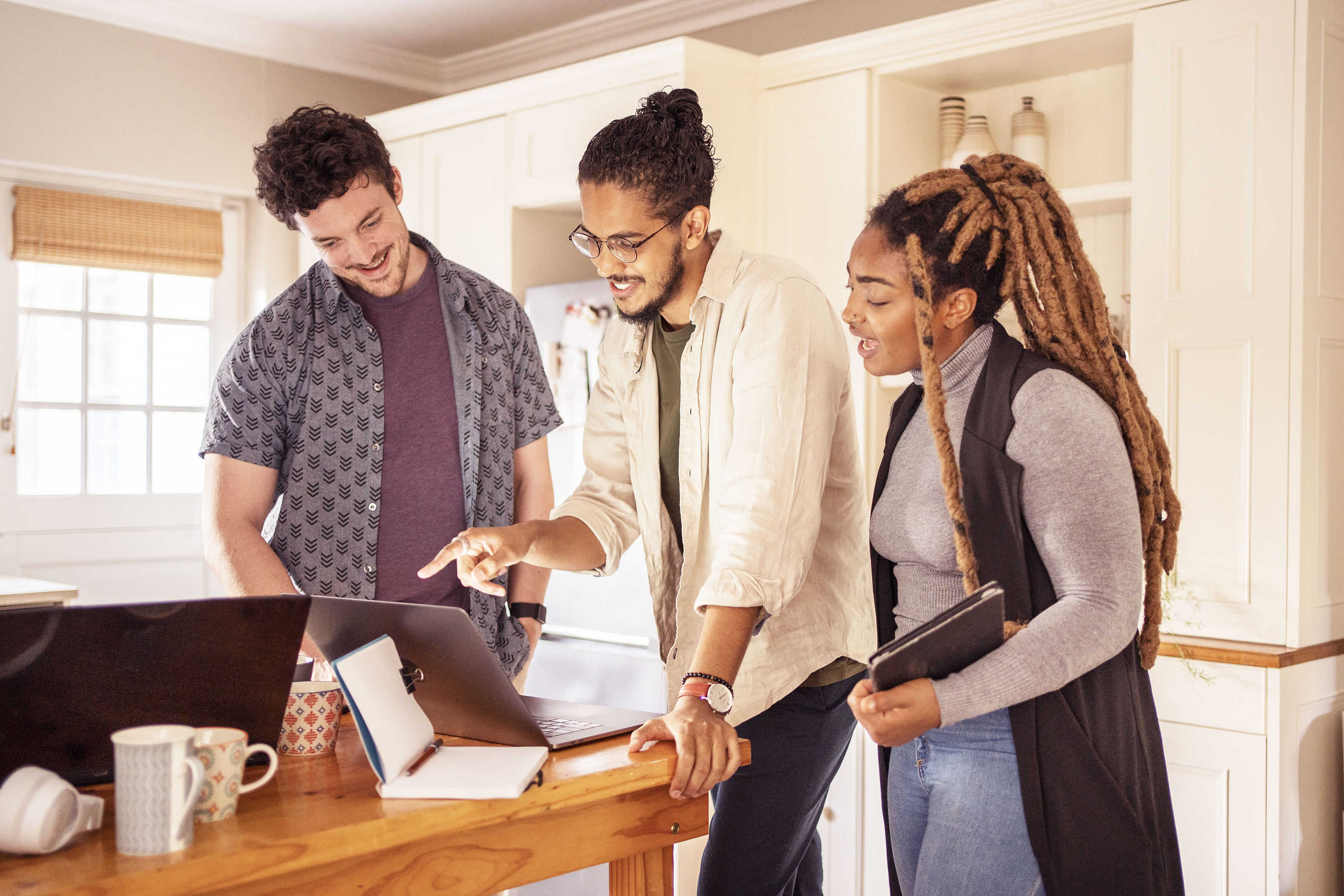 Coworkers meeting by a laptop