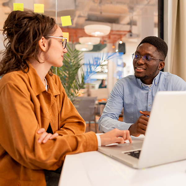 Coworkers meeting by a laptop